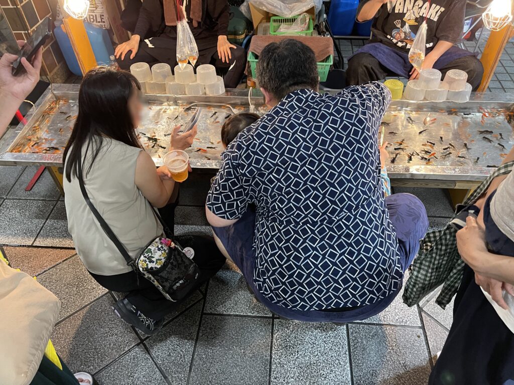 金魚すくいに後からやってきた家族連れ